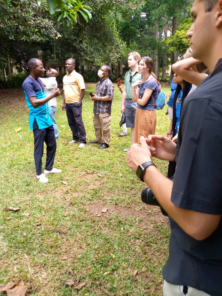 Students and faculty listening to guide in Aburi Gardens. 