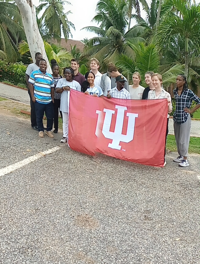 Students and faculty holding IU banner.
